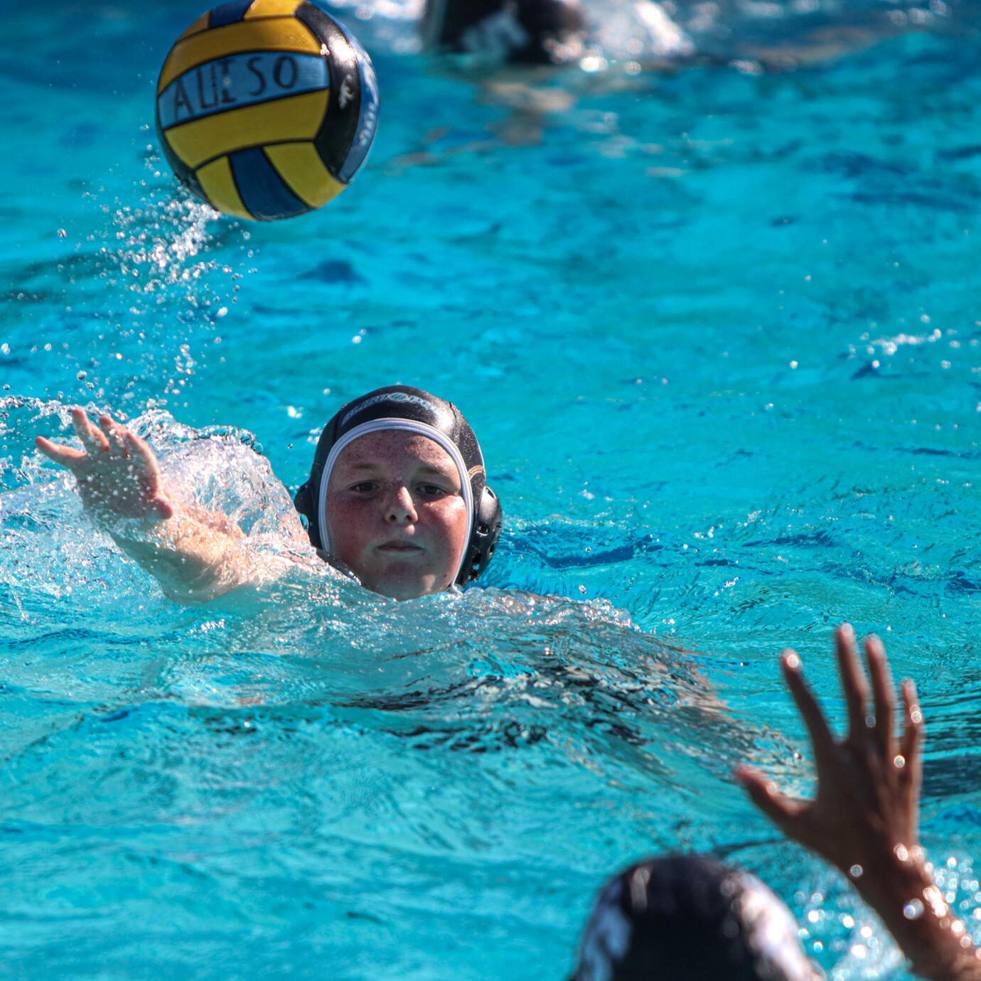 Fierce water polo action with players vying for control.